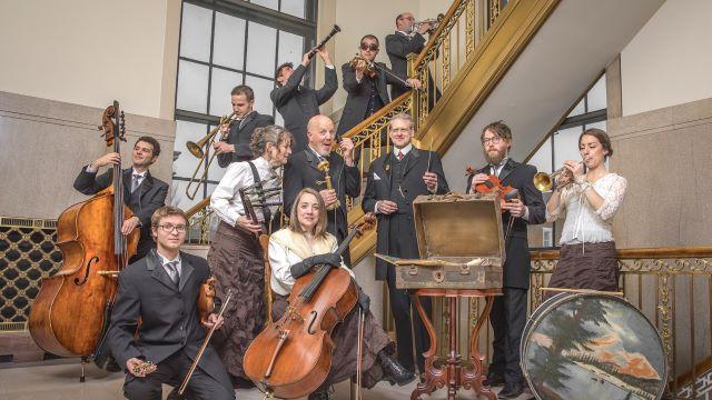 在一个古老的楼梯上，以各种姿势排列的拉格泰姆管弦乐队的典范. 他们都穿着古装，拿着乐器.